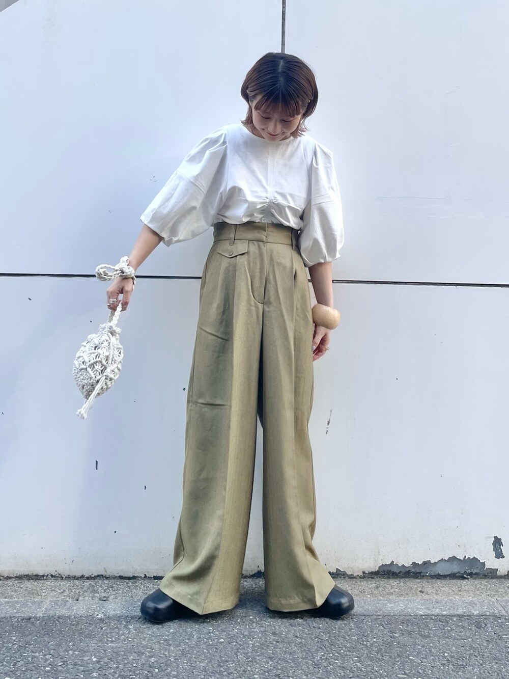 ホワイト系のTシャツ/カットソー、グリーン系のその他パンツ、ブラック系のサンダルを着用したレディースの春コーディネートの2枚目の写真