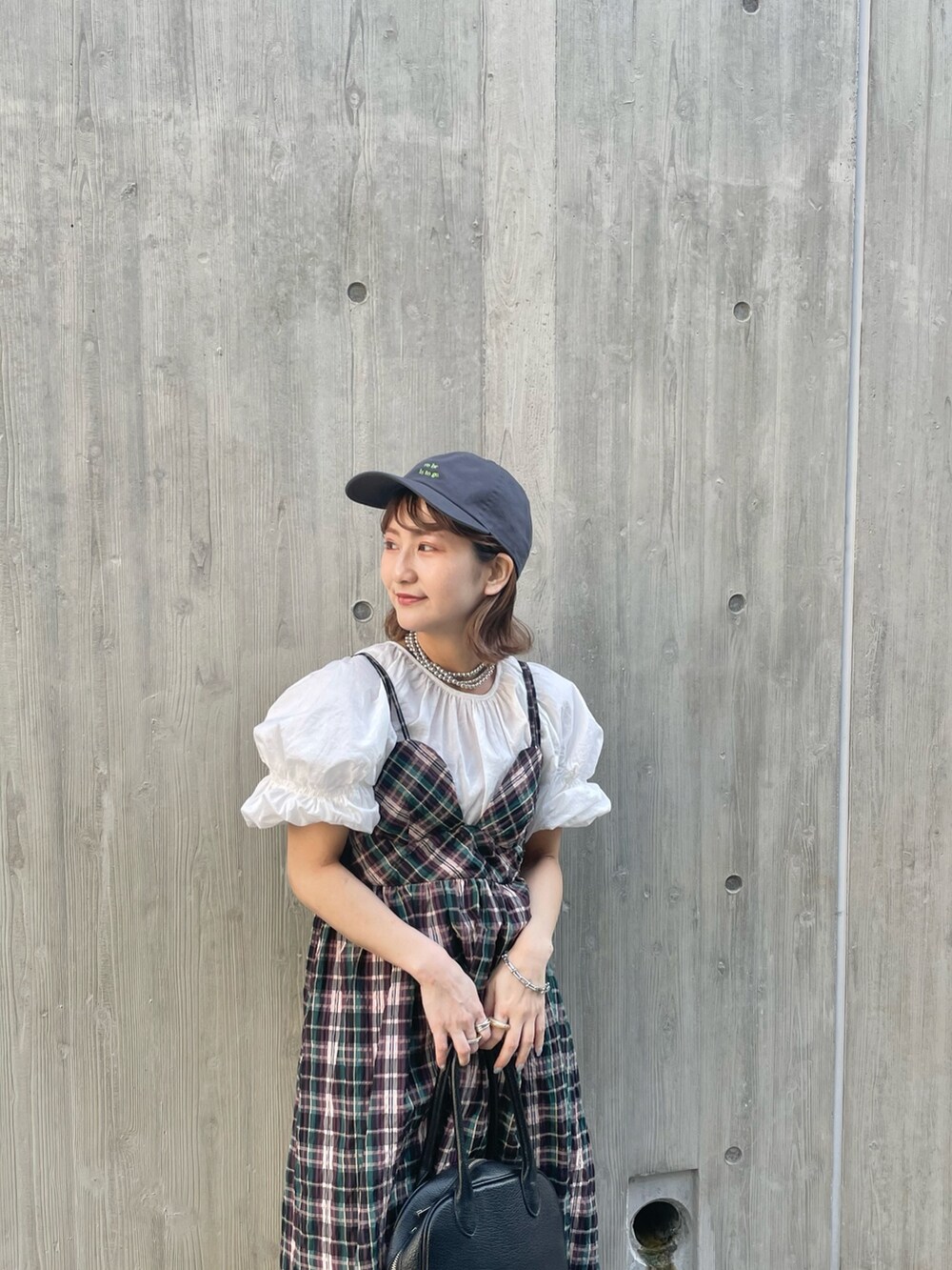 ブルー系のワンピース、ブラック系のサンダル、ホワイト系のシャツ/ブラウスを着用したレディースの春コーディネートの2枚目の写真