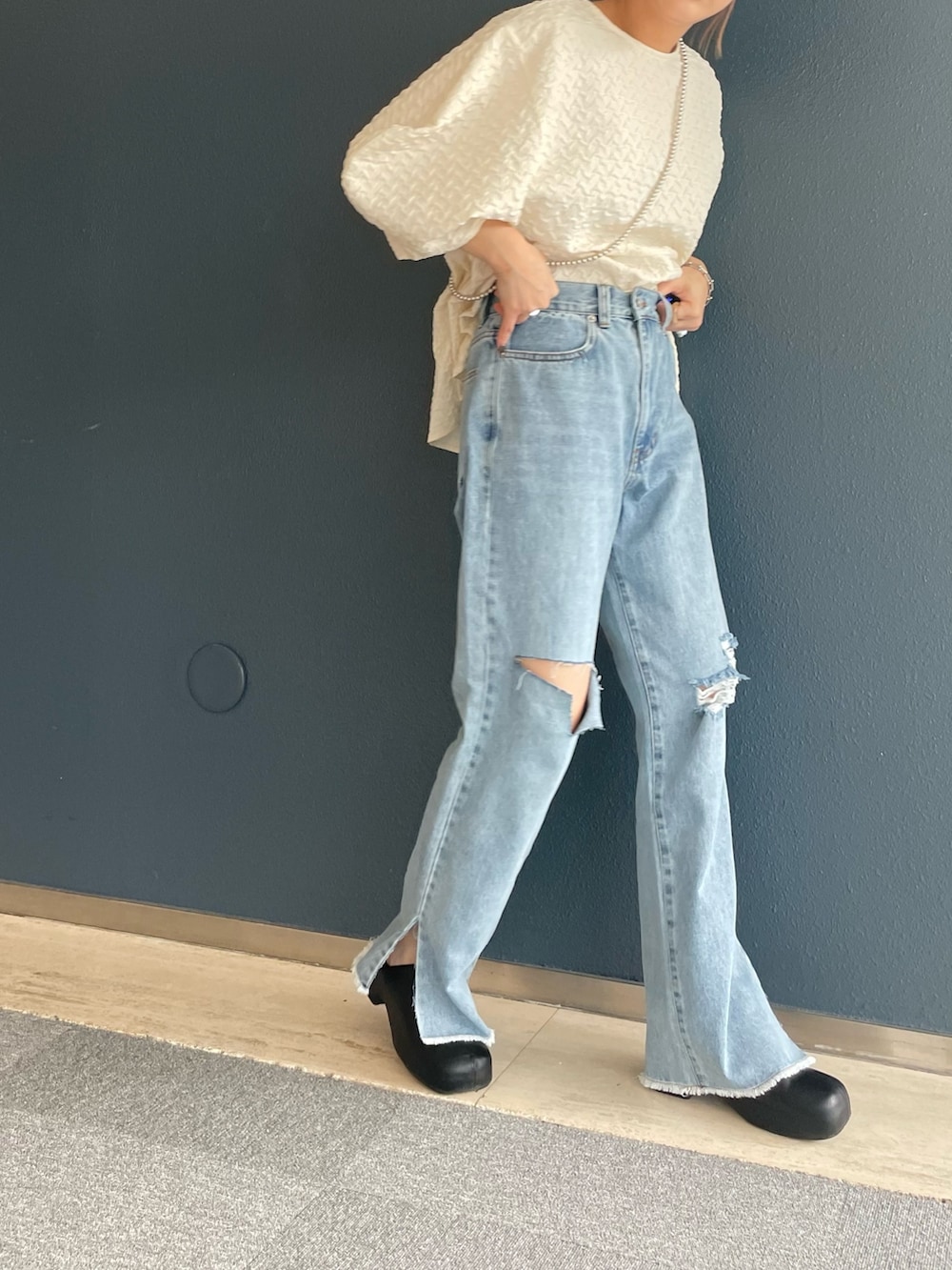 ブルー系のデニムパンツ、ホワイト系のシャツ/ブラウス、ホワイト系のショルダーバッグを着用したレディースの夏コーディネートの3枚目の写真