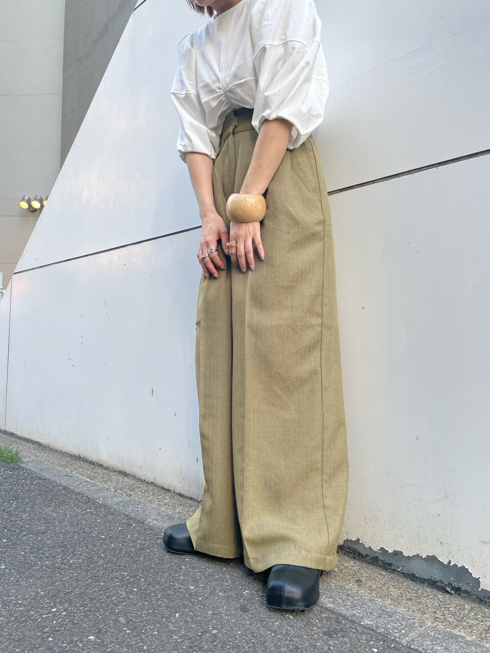 ホワイト系のTシャツ/カットソー、グリーン系のその他パンツ、ブラック系のサンダルを着用したレディースの春コーディネートの5枚目の写真