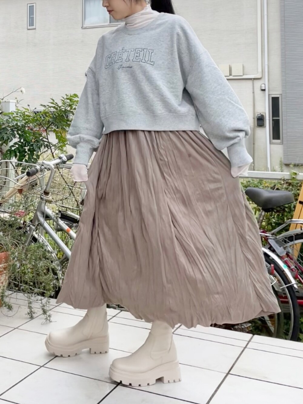 ブラウン系のスカート、グレー系のスウェット、ホワイト系のTシャツ/カットソーを着用したレディースの秋コーディネートの2枚目の写真