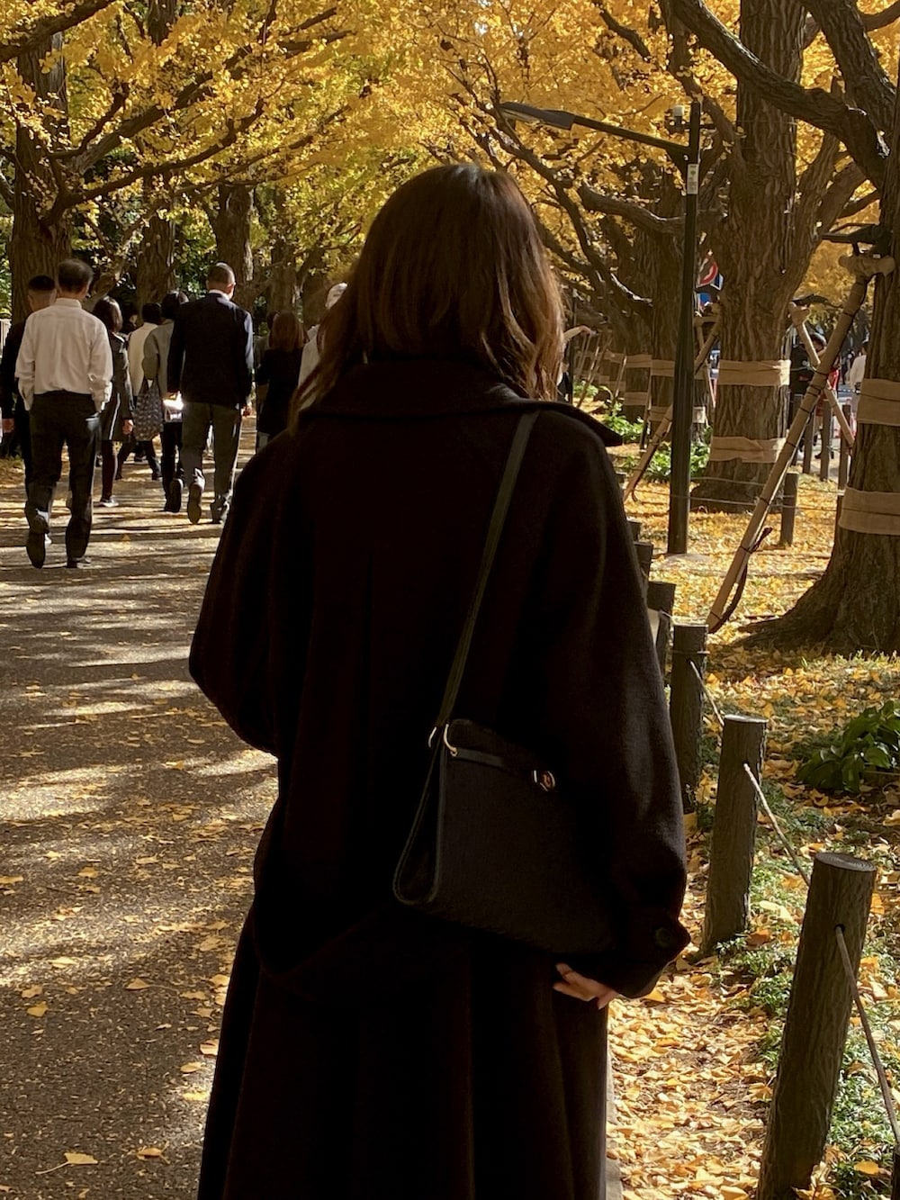 グレー系のニット/セーター、ブラック系のステンカラーコート、ブラック系のその他パンツを着用したレディースの冬コーディネートの3枚目の写真