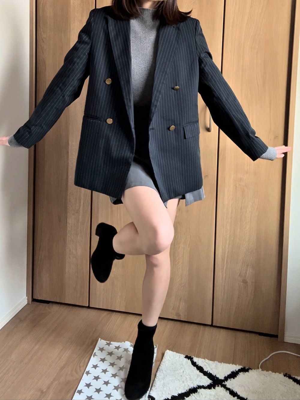 ブルー系のテーラードジャケット、ブラック系のスカートを着用したレディースの冬コーディネートの2枚目の写真