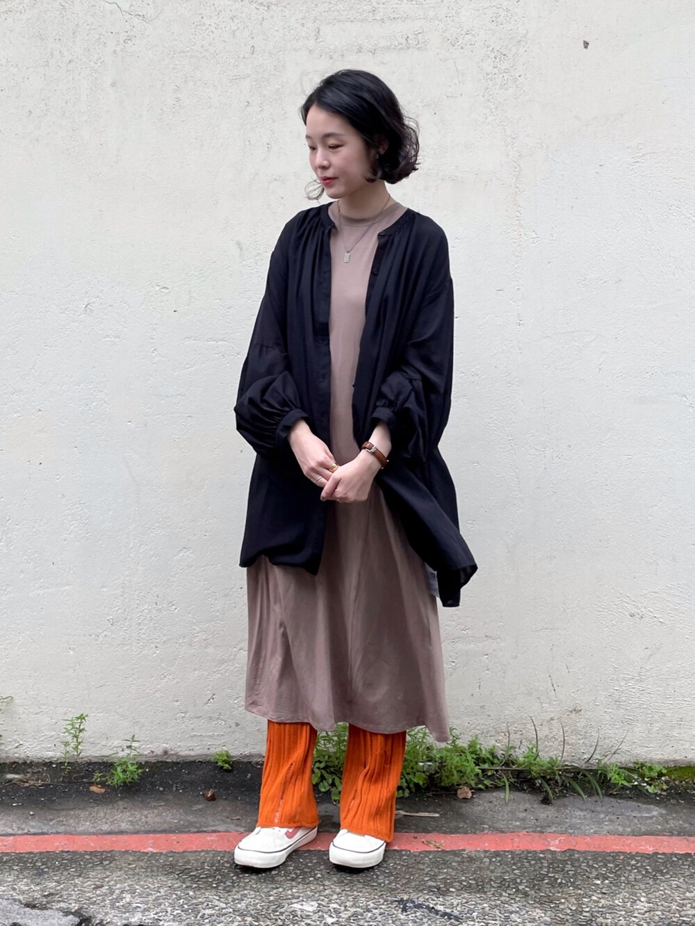 ブラック系のシャツ/ブラウス、オレンジ系のその他パンツ、ホワイト系のスニーカーを着用したレディースの秋コーディネートの2枚目の写真