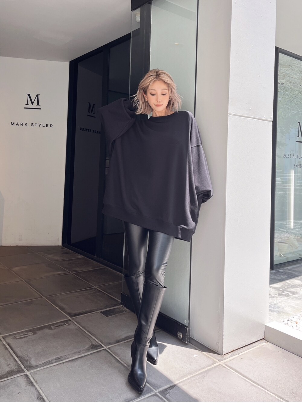 ブラック系のスウェット、ブラック系のブーツを着用したレディースの冬コーディネートの2枚目の写真