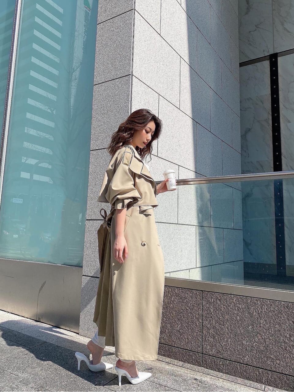 ベージュ系のトレンチコート、ホワイト系のデニムパンツ、ホワイト系のニット/セーターを着用したレディースの春コーディネートの5枚目の写真