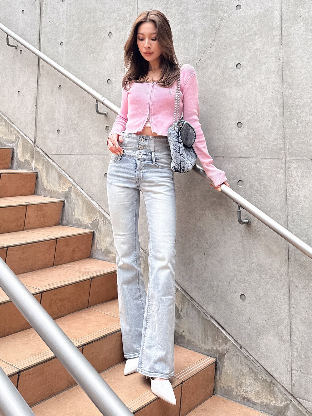 ブルー系のデニムパンツ、ピンク系のニット/セーターを着用したレディースの春コーディネートの3枚目の写真