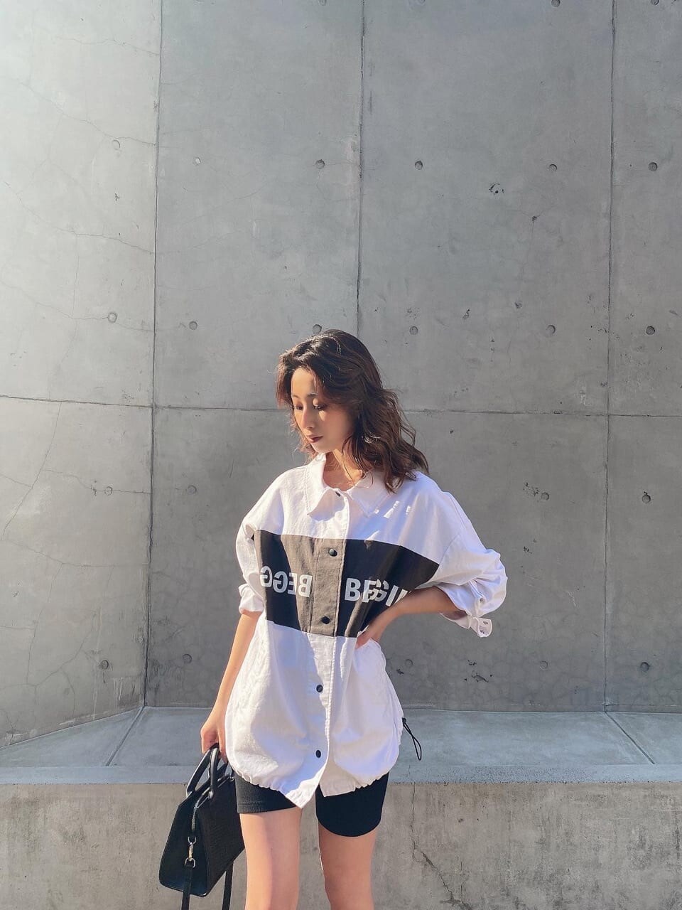 ホワイト系のブルゾン、ブラック系のレギンス/スパッツを着用したレディースの春コーディネートの4枚目の写真