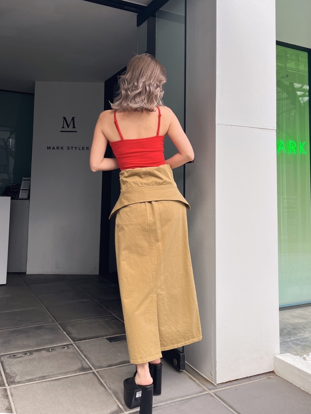 グリーン系のスカート、レッド系のキャミソール、ブラック系のサンダルを着用したレディースの夏コーディネートの4枚目の写真