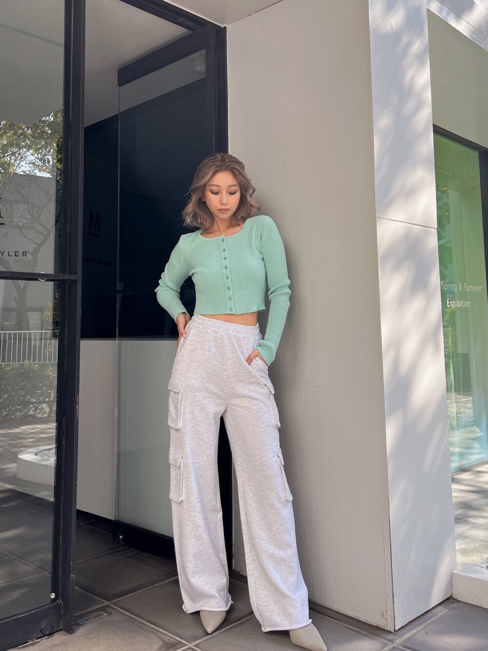 グレー系のカーゴパンツ、グリーン系のカーディガン/ボレロ、ベージュ系のパンプスを着用したレディースの冬コーディネートの2枚目の写真