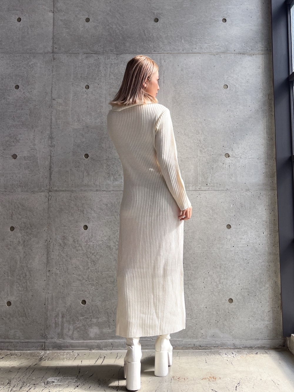 ブラック系のブーツ、ホワイト系のワンピースを着用したレディースの冬コーディネートの2枚目の写真