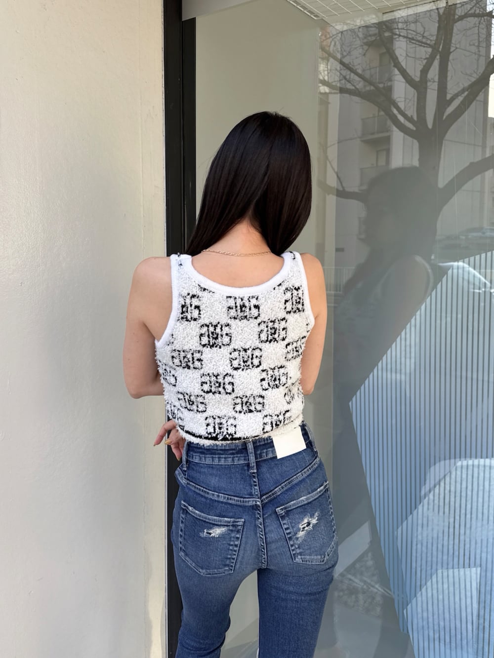 ホワイト系のニット/セーター、ブルー系のデニムパンツを着用したレディースの夏コーディネートの3枚目の写真