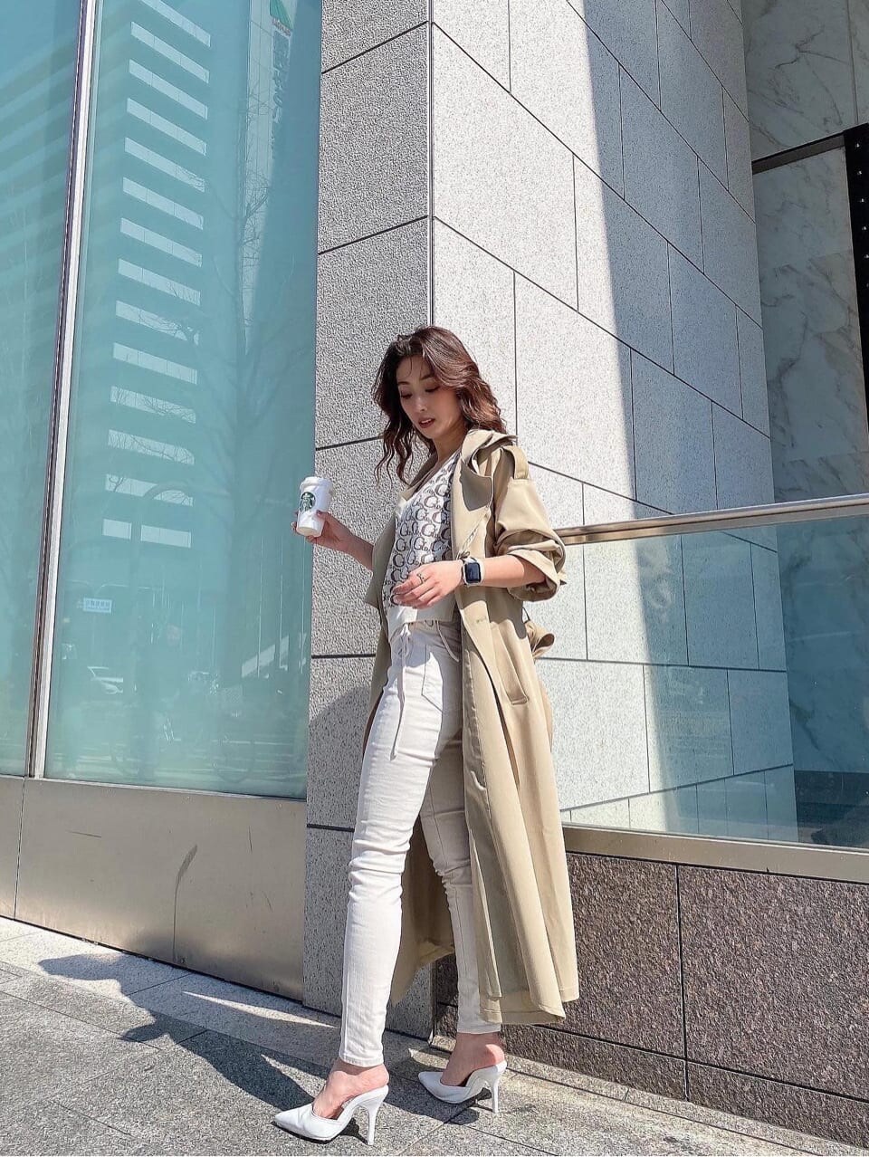 ベージュ系のトレンチコート、ホワイト系のデニムパンツ、ホワイト系のニット/セーターを着用したレディースの春コーディネートの7枚目の写真