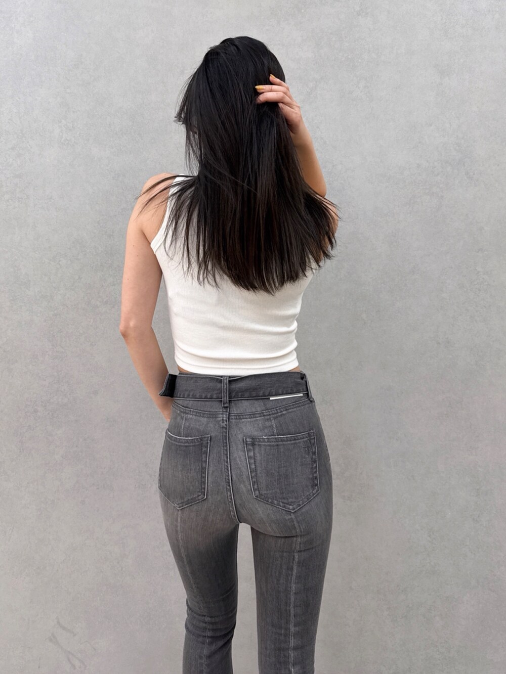 ブラック系のデニムパンツ、ホワイト系のタンクトップを着用したレディースの夏コーディネートの4枚目の写真