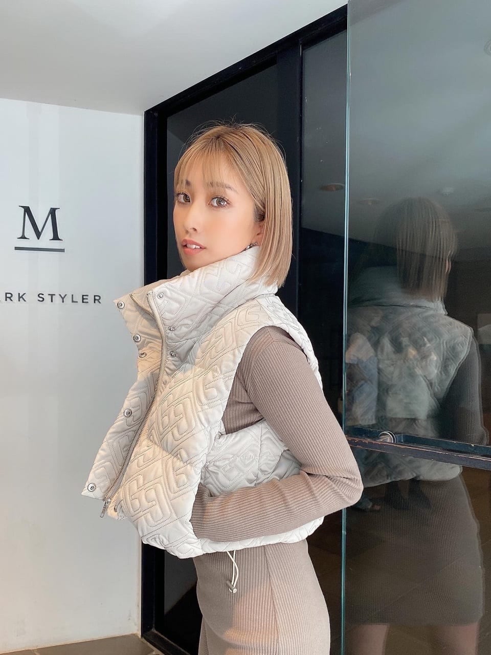 ホワイト系のブーツ、ホワイト系のその他アウター、ベージュ系のワンピースを着用したレディースの秋コーディネートの3枚目の写真