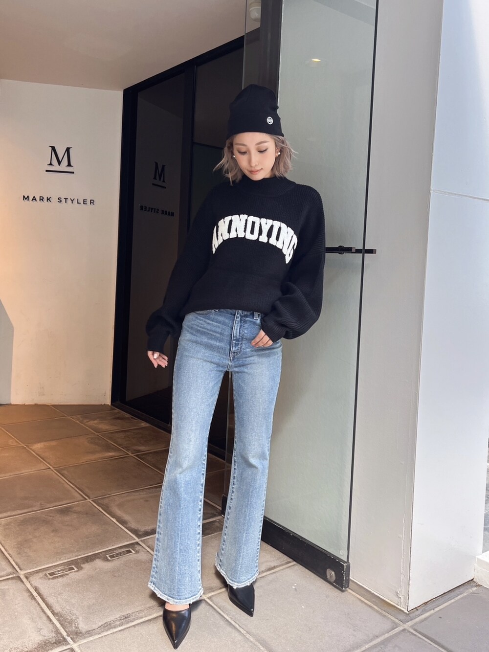 ブラック系のニット/セーター、ブルー系のデニムパンツを着用したレディースの冬コーディネートの3枚目の写真