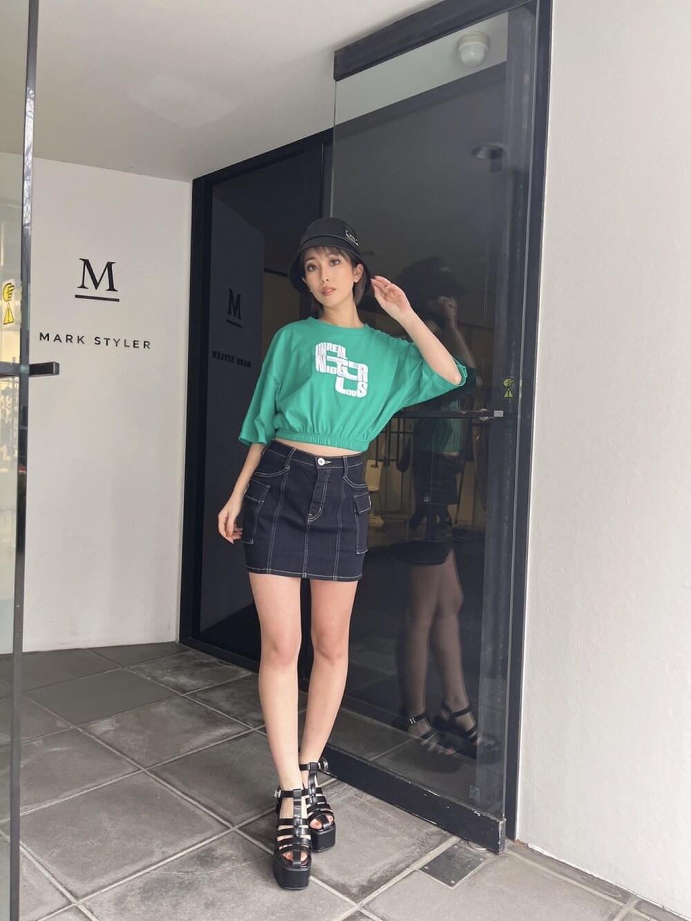 グリーン系のTシャツ/カットソー、ブルー系のデニムスカートを着用したレディースの夏コーディネートの3枚目の写真