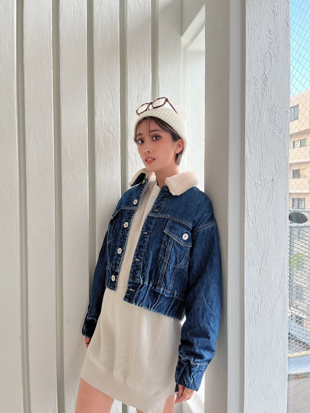 ホワイト系のニット/セーター、ブルー系のデニムジャケット、ブラック系のブーツを着用したレディースの秋コーディネートの4枚目の写真