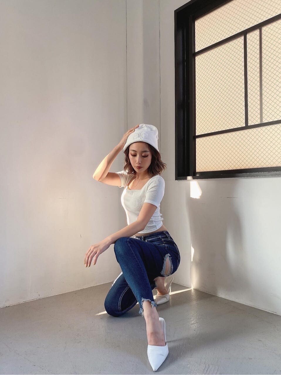 ホワイト系のパンプス、ブルー系のデニムパンツ、ホワイト系のTシャツ/カットソーを着用したレディースの夏コーディネートの2枚目の写真