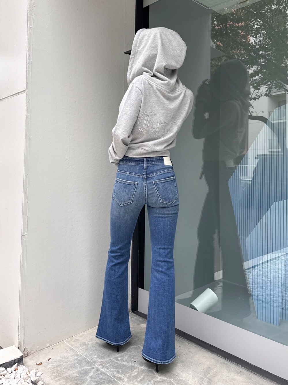 ブルー系のデニムパンツ、グレー系のパーカーを着用したレディースの春コーディネートの3枚目の写真