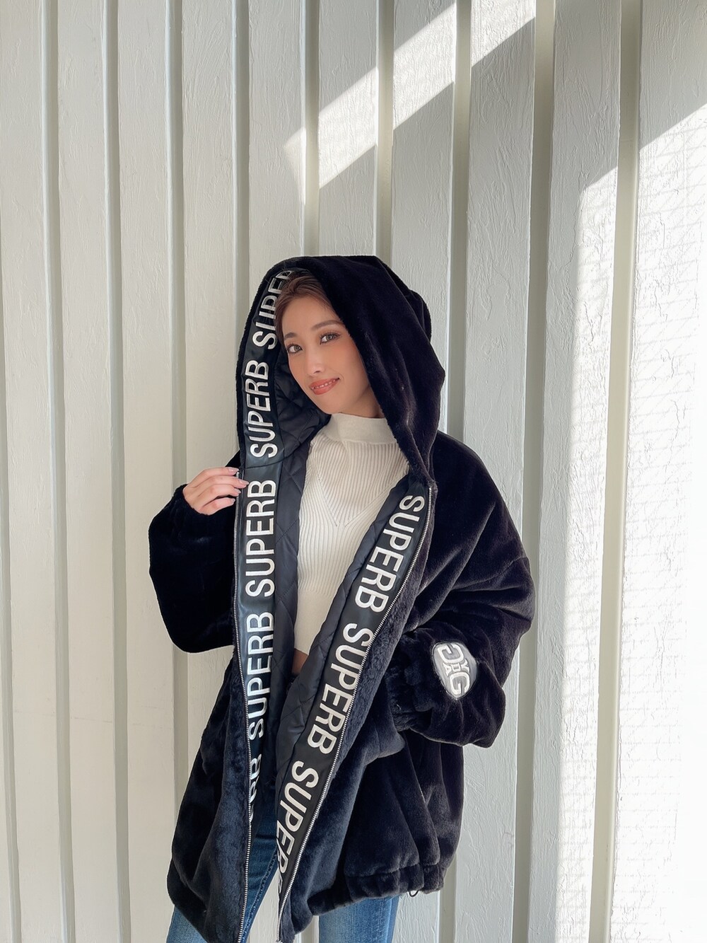 ブラック系のブルゾン、ブルー系のデニムパンツ、ブラック系のパンプスを着用したレディースの秋コーディネートの5枚目の写真