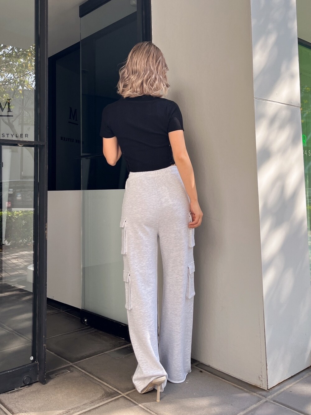 ブラック系のニット/セーター、グレー系のカーゴパンツ、ベージュ系のパンプスを着用したレディースの春コーディネートの3枚目の写真