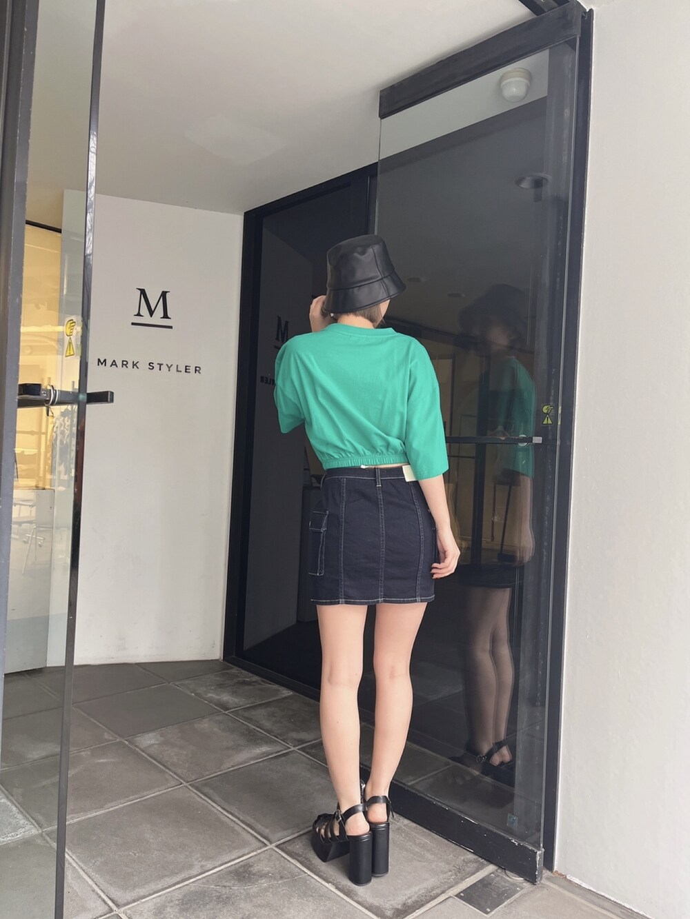 グリーン系のTシャツ/カットソー、ブルー系のデニムスカートを着用したレディースの夏コーディネートの4枚目の写真