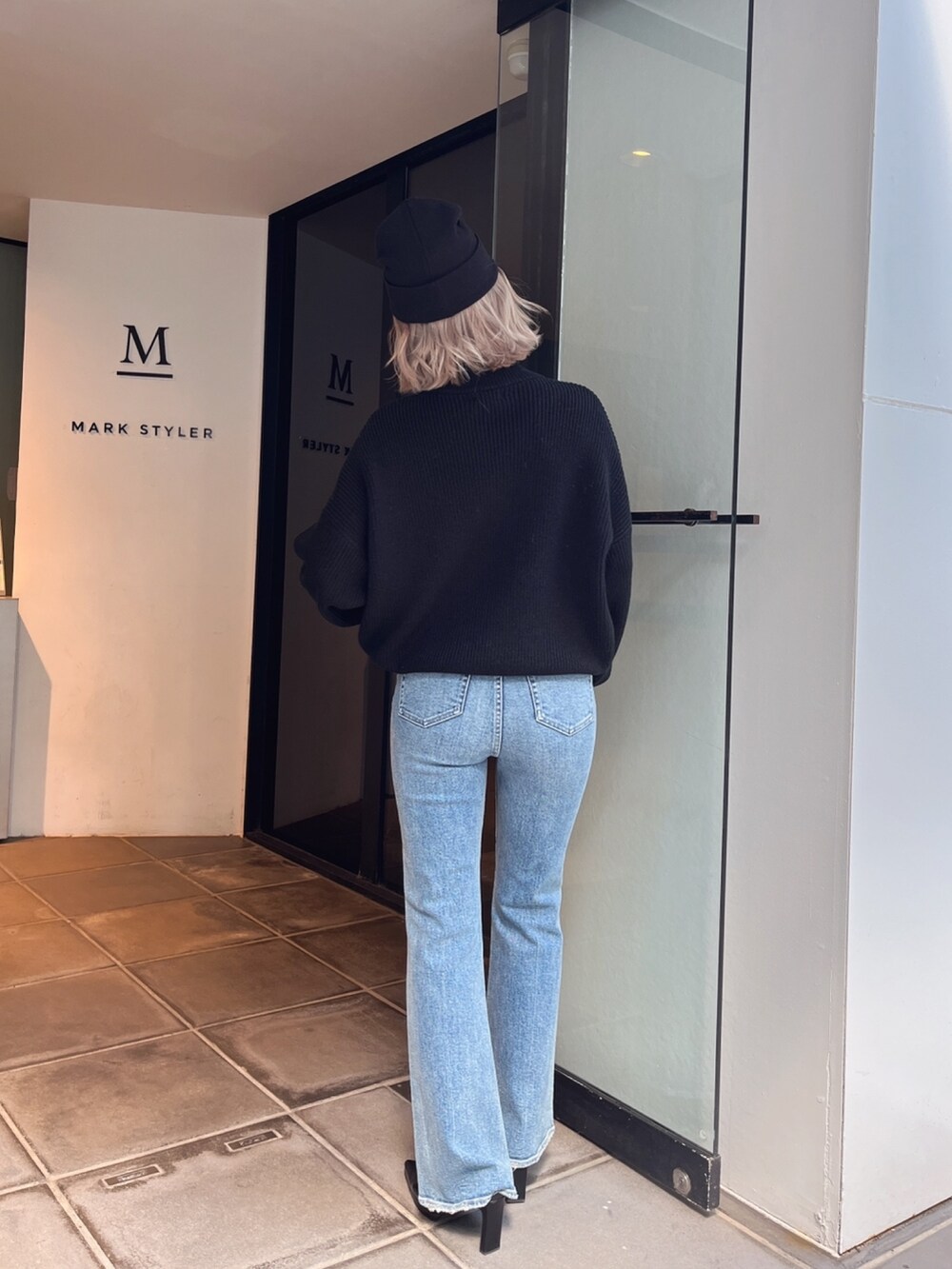 ブラック系のニット/セーター、ブルー系のデニムパンツを着用したレディースの冬コーディネートの4枚目の写真