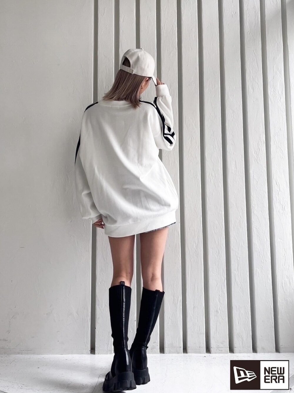 ホワイト系のスウェット、ブラック系のブーツを着用したレディースの春コーディネートの2枚目の写真