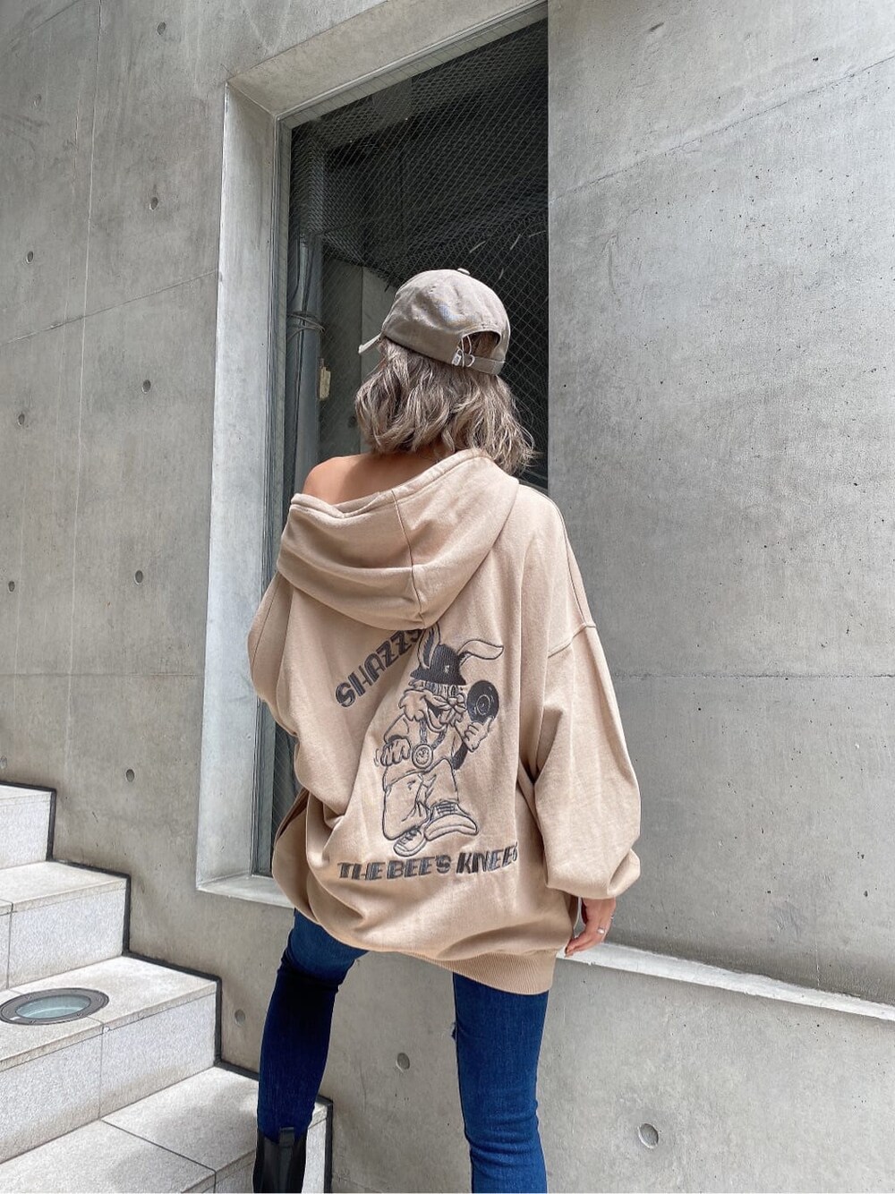 ブルー系のデニムパンツ、ベージュ系のパーカー、ベージュ系のキャップを着用したレディースの秋コーディネートの6枚目の写真