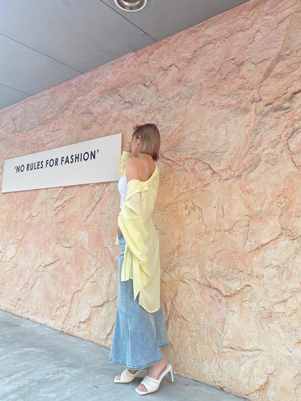 イエロー系のシャツ/ブラウス、ブルー系のデニムスカート、ホワイト系のサンダルを着用したレディースの夏コーディネートの2枚目の写真