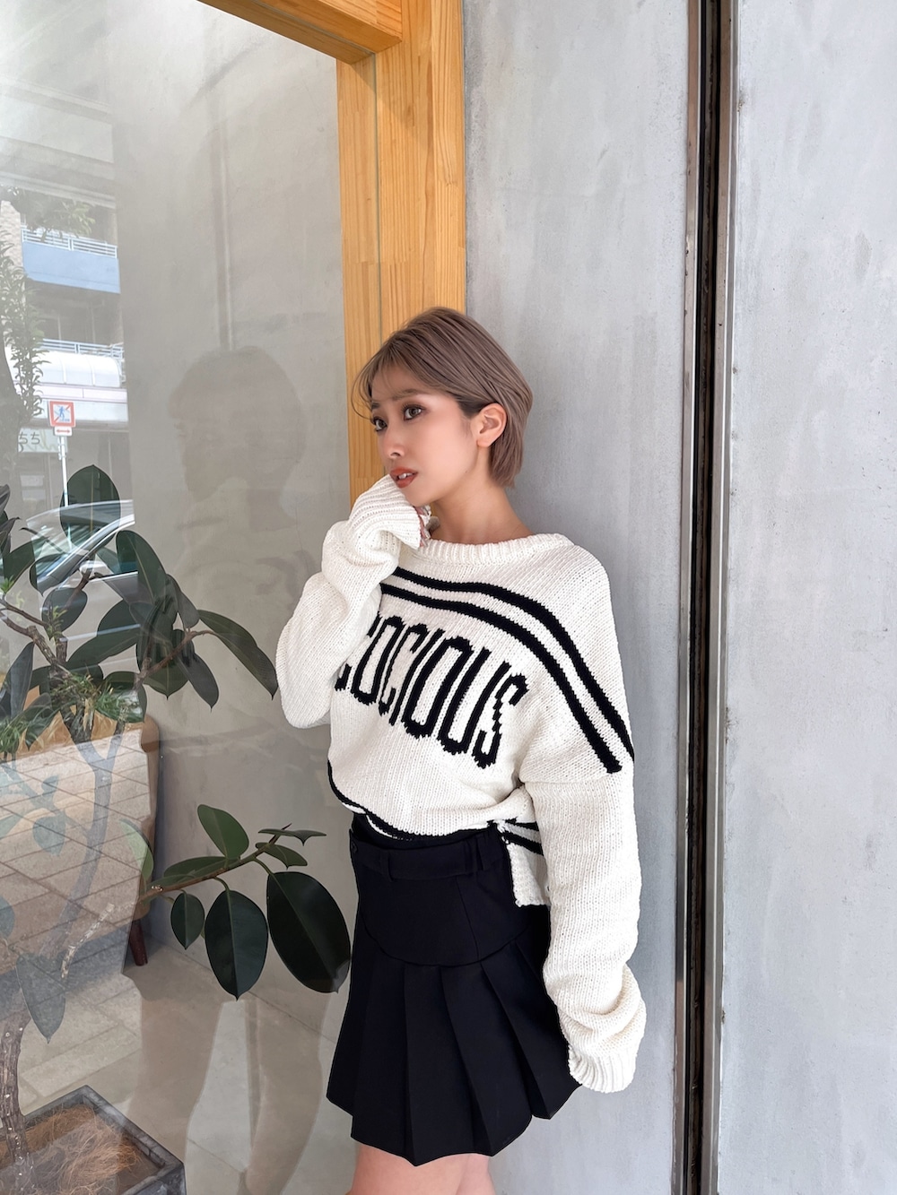 ホワイト系のニット/セーター、ブラック系のスカート、ブラック系のブーツを着用したレディースの冬コーディネートの4枚目の写真