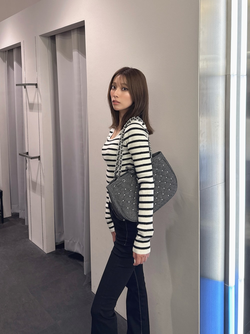 ブラック系のデニムパンツ、ブラック系のブーツ、その他のニット/セーターを着用したレディースの秋コーディネートの5枚目の写真
