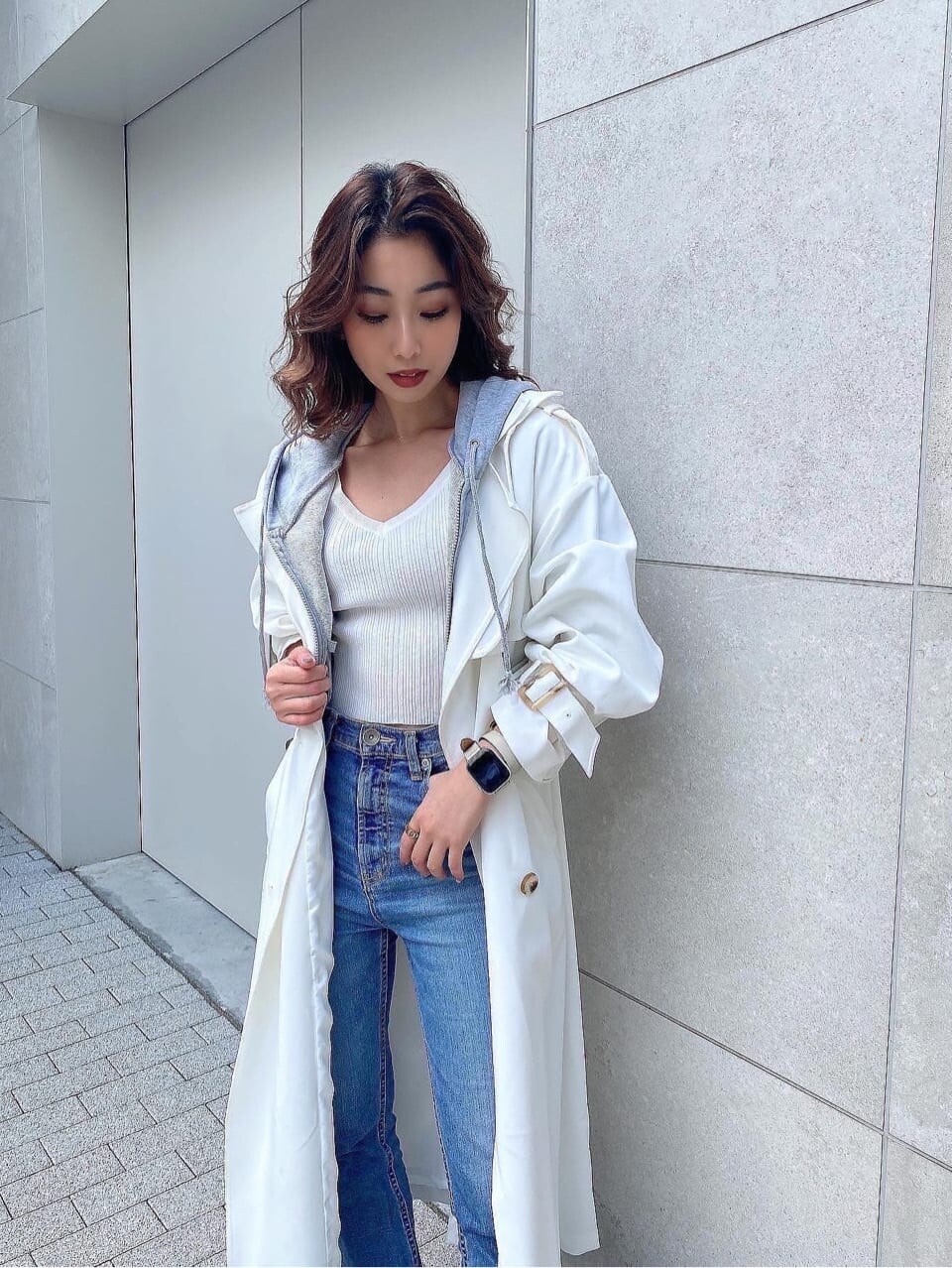 ブラック系のパンプス、ホワイト系のトレンチコート、ホワイト系のニット/セーターを着用したレディースの冬コーディネートの7枚目の写真