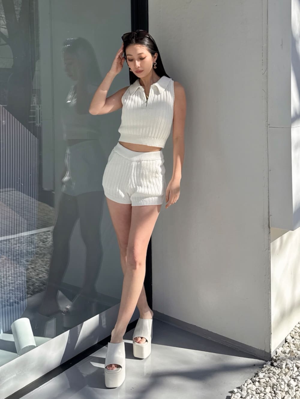 ホワイト系のニット/セーターを着用したレディースの夏コーディネートの2枚目の写真