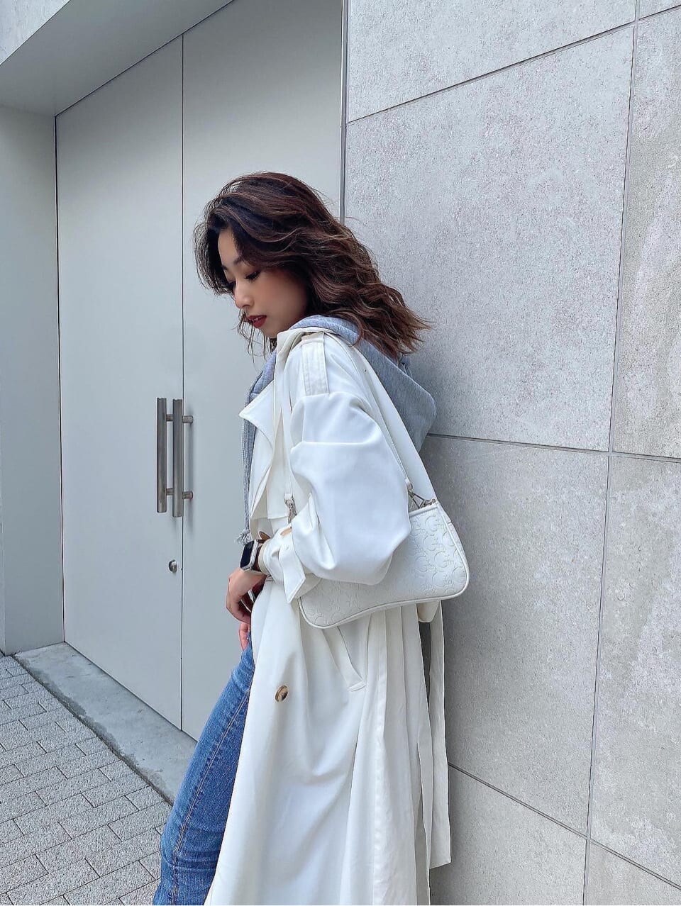 ブラック系のパンプス、ホワイト系のトレンチコート、ホワイト系のニット/セーターを着用したレディースの冬コーディネートの6枚目の写真