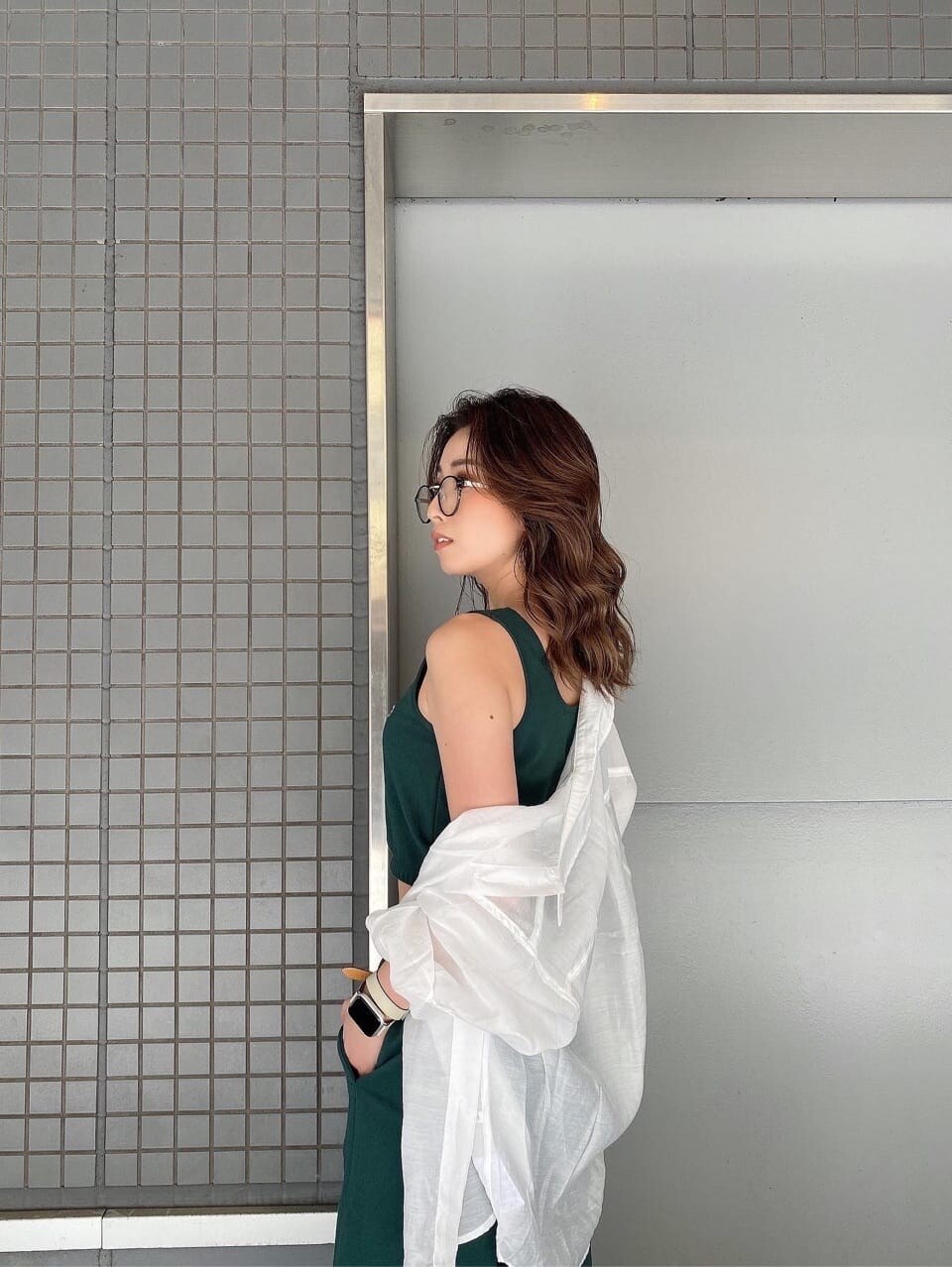 ホワイト系のパンプス、グリーン系のスウェットパンツ、グリーン系のキャミソールを着用したレディースの春コーディネートの8枚目の写真