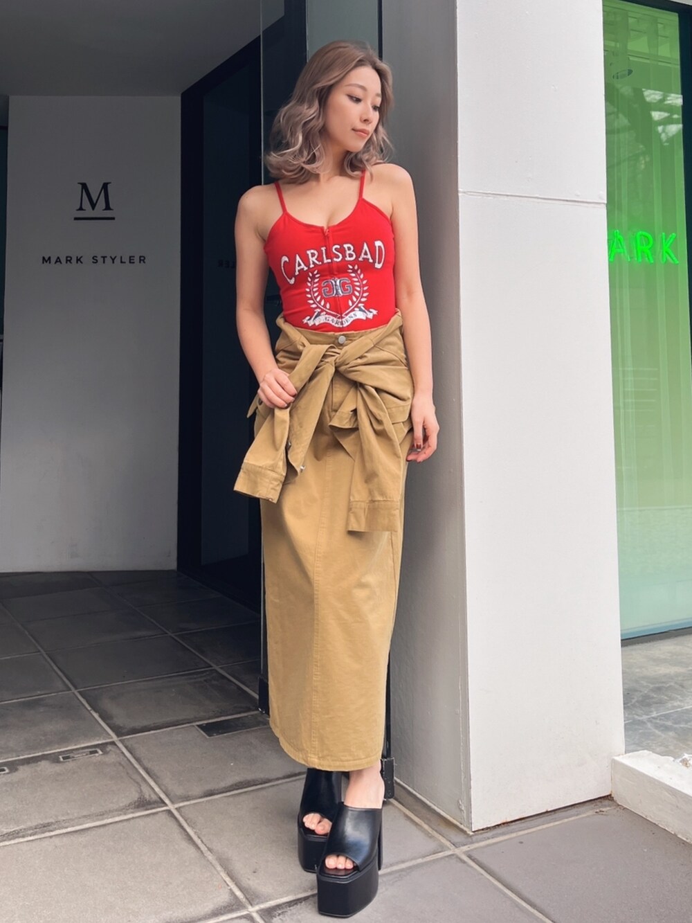 グリーン系のスカート、レッド系のキャミソール、ブラック系のサンダルを着用したレディースの夏コーディネートの3枚目の写真