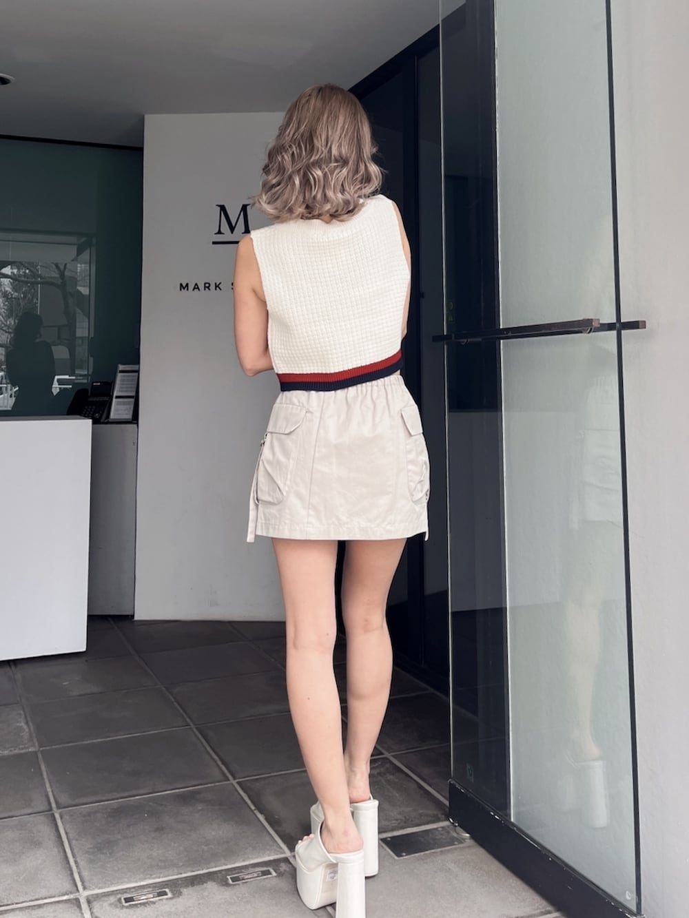 ホワイト系のニット/セーター、ホワイト系のカーゴパンツ、ブラック系のサンダルを着用したレディースの秋コーディネートの3枚目の写真