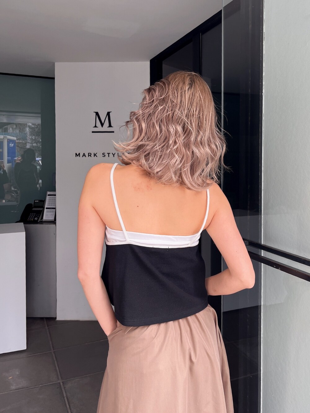 ホワイト系のキャミソール、ベージュ系のスカートを着用したレディースの夏コーディネートの4枚目の写真