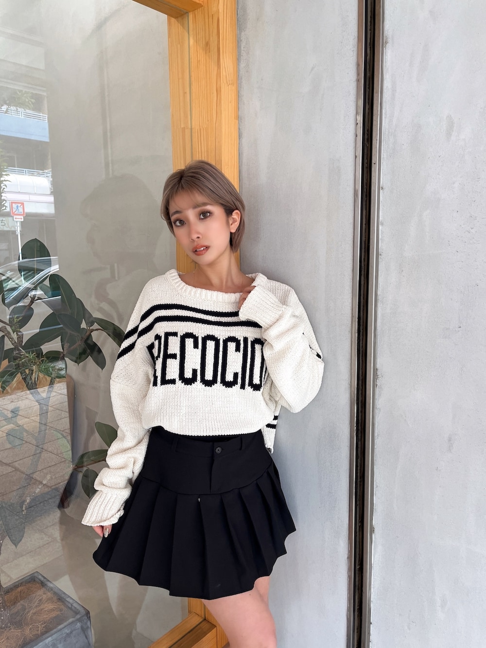 ホワイト系のニット/セーター、ブラック系のスカート、ブラック系のブーツを着用したレディースの冬コーディネートの3枚目の写真