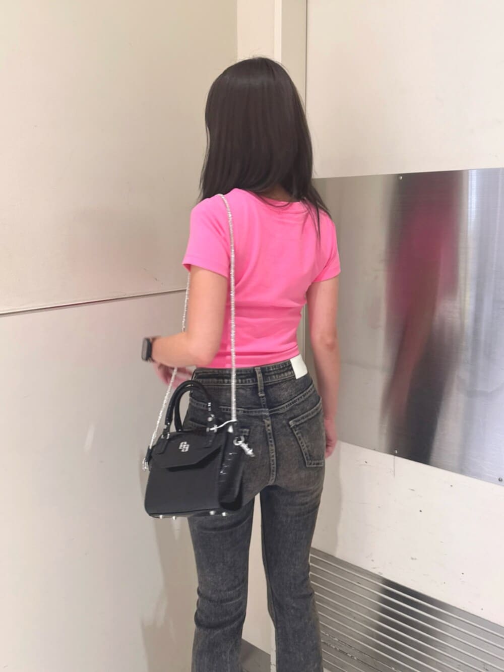 ブラック系のハンドバッグ、ブラック系のサンダル、ブルー系のデニムパンツを着用したレディースの夏コーディネートの6枚目の写真