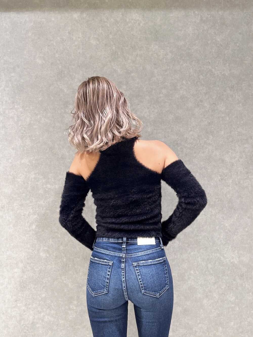 ブラック系のニット/セーター、ブルー系のデニムパンツを着用したレディースの冬コーディネートの4枚目の写真