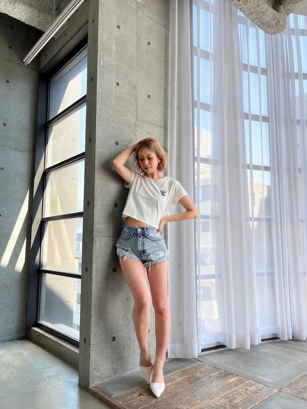 ブルー系のデニムパンツ、ホワイト系のTシャツ/カットソー、ホワイト系のパンプスを着用したレディースの春コーディネートの2枚目の写真