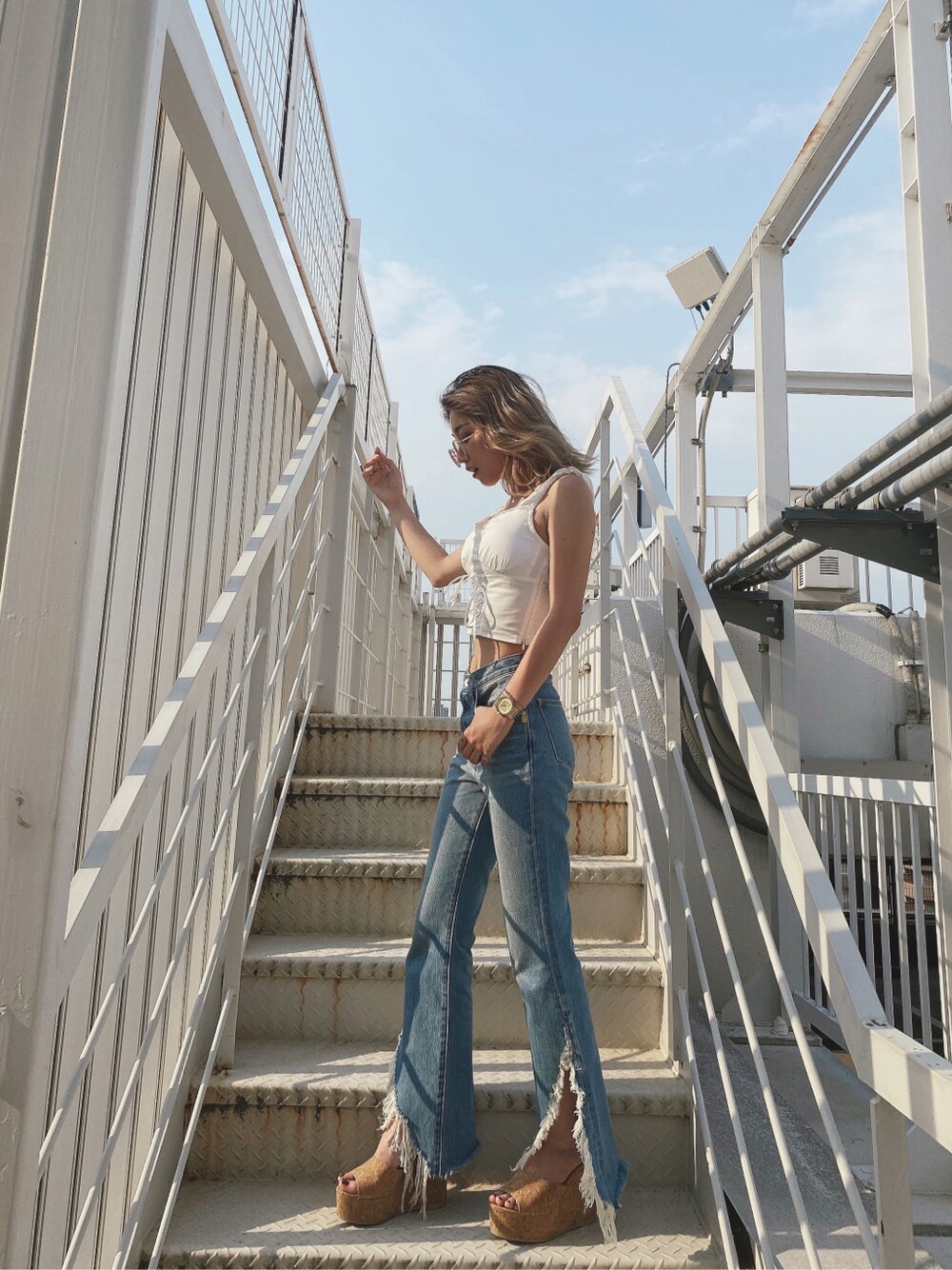 ベージュ系のサンダル、ブルー系のデニムパンツ、ホワイト系のシャツ/ブラウスを着用したレディースの夏コーディネートの2枚目の写真