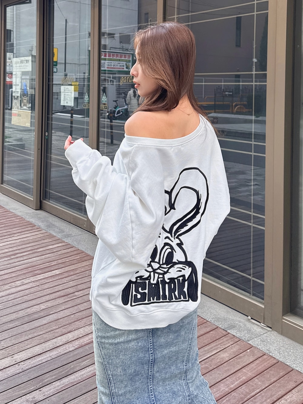 ホワイト系のスウェット、ブルー系のデニムスカートを着用したレディースの冬コーディネートの3枚目の写真