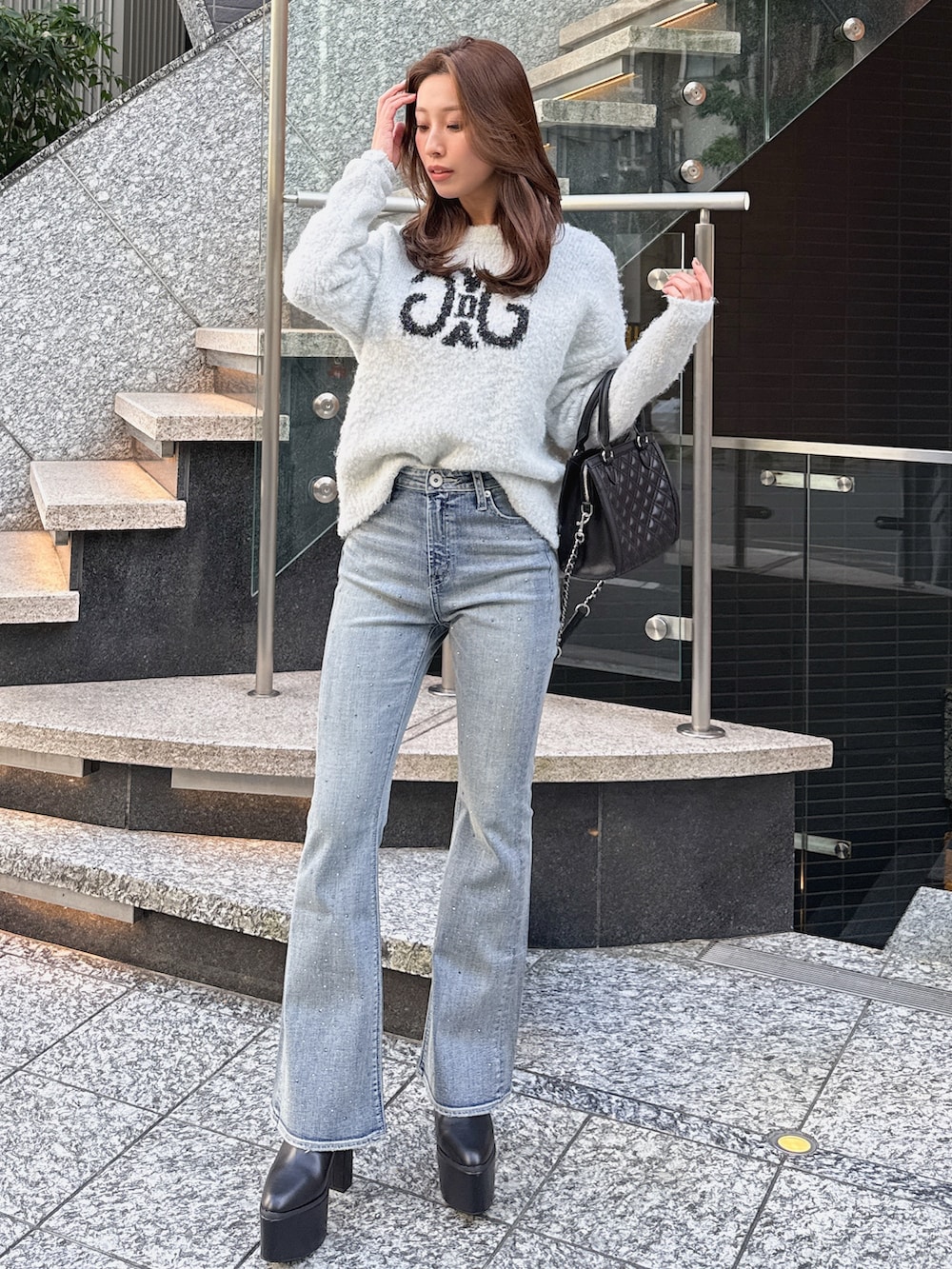 ブルー系のデニムパンツ、ホワイト系のニット/セーターを着用したレディースの冬コーディネートの2枚目の写真