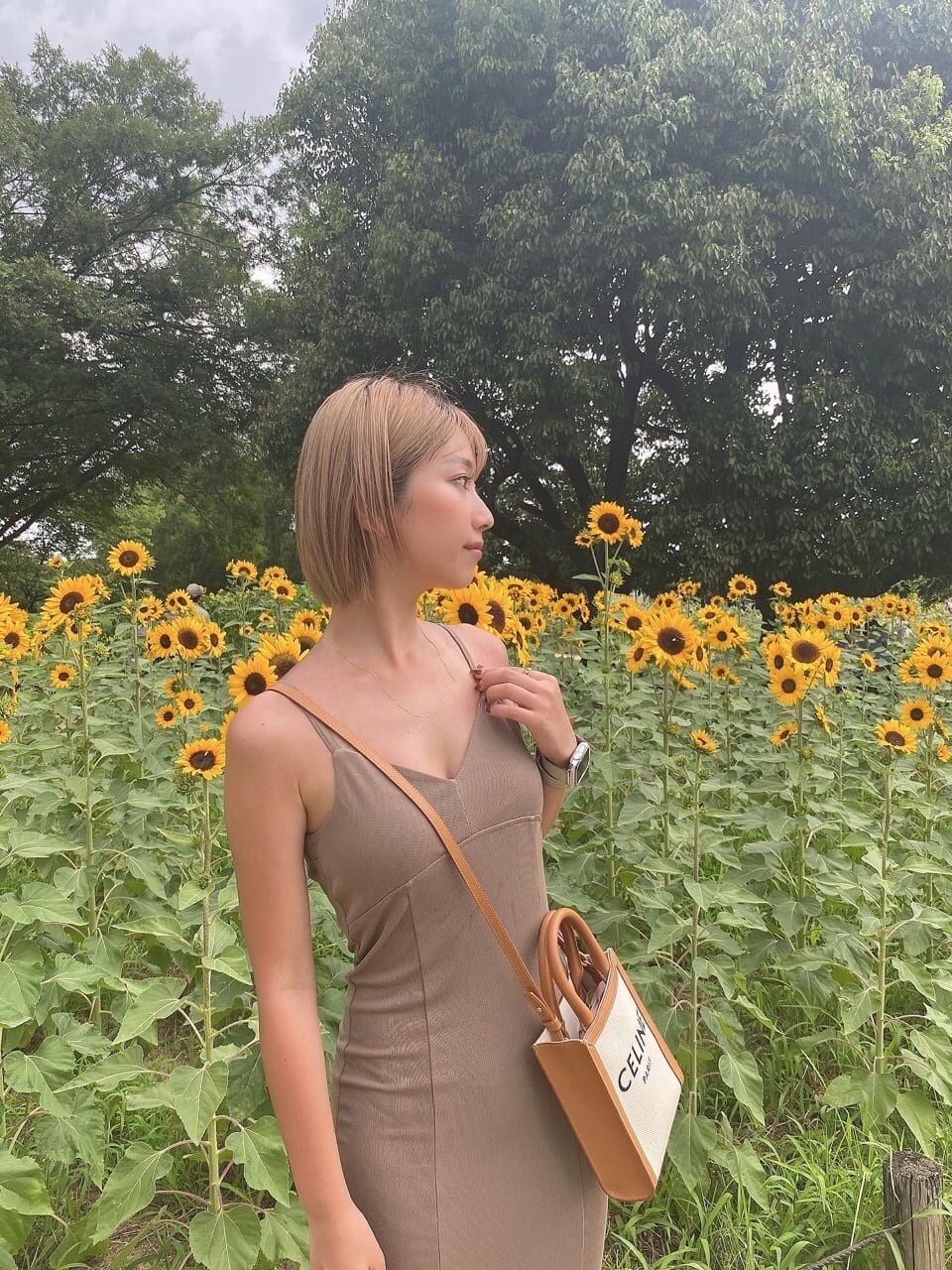 ベージュ系のワンピースを着用したレディースの夏コーディネートの2枚目の写真