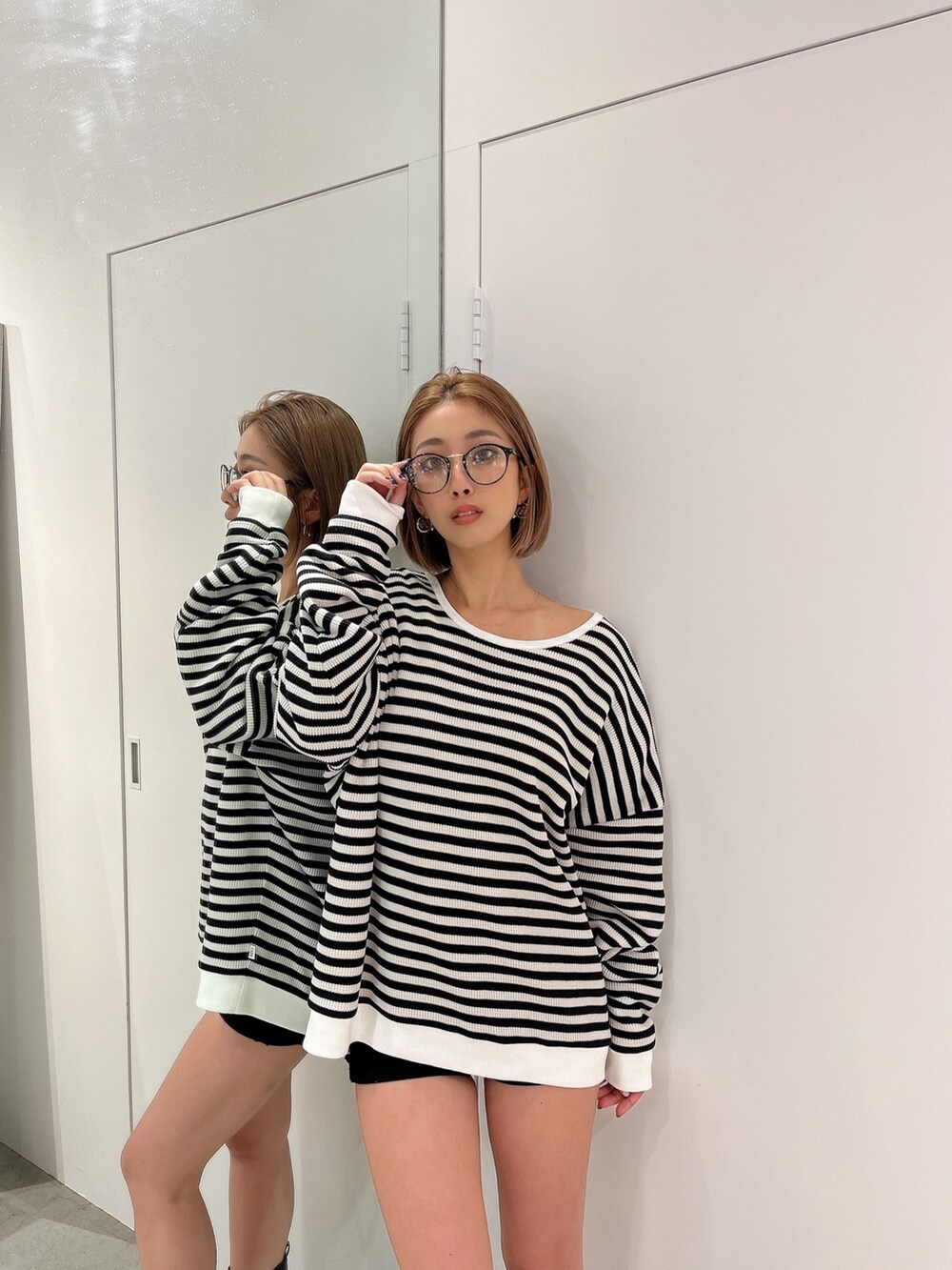 ホワイト系のスウェット、ブラウン系のブーツ、その他のサングラスを着用したレディースの秋コーディネートの6枚目の写真