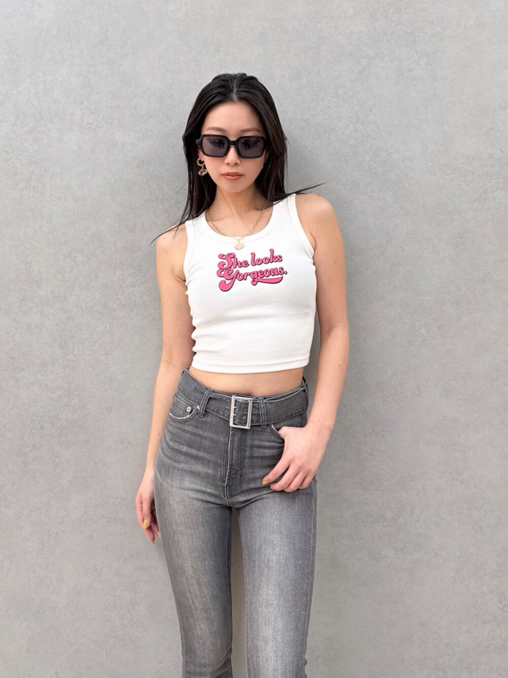 ブラック系のデニムパンツ、ホワイト系のタンクトップを着用したレディースの夏コーディネートの5枚目の写真